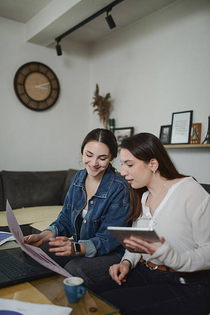 istock Two Women Collaborating at Home Office Setting With Laptop, Tablet, and Documents 2239798248