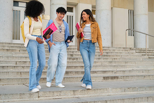 istock Diverse students walking downstairs talking and laughing on campus 2239800496
