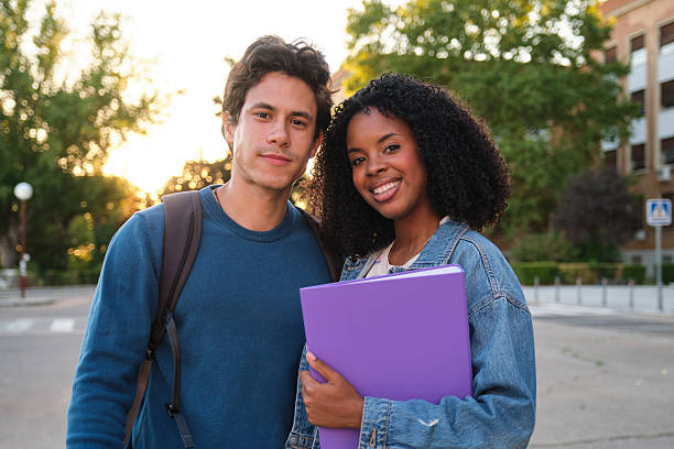 istock Diverse young adult students smiling on university campus 2239803974