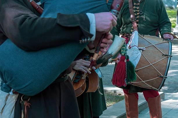 istock Musicians playing traditional medieval instruments outdoors during a historical festival reenactment event 2239804526