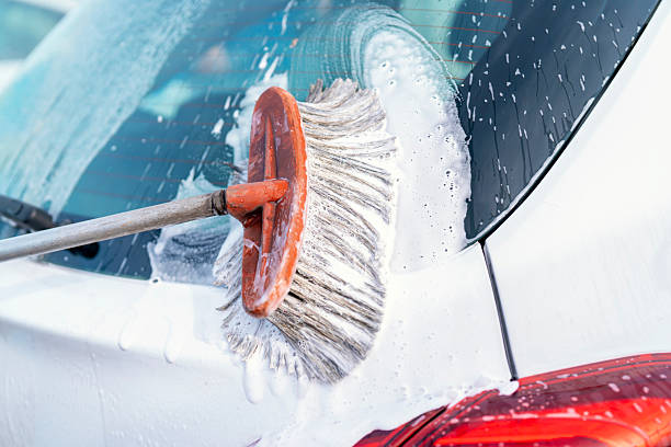 istock Soapy water runs down the surface of vehicle's window capturing bubbles in the warm sunlight as gentle breeze enhances the soothing atmosphere of the car wash 2239804708