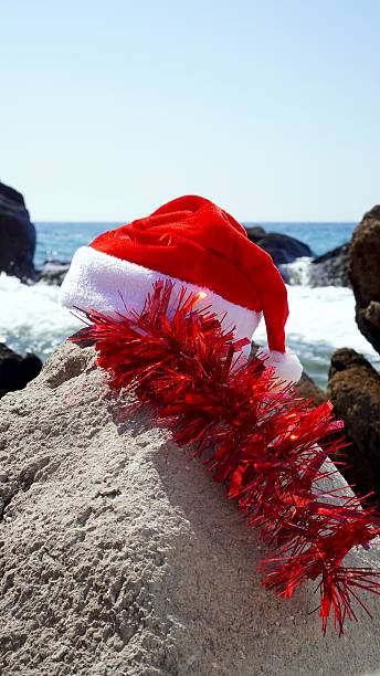 istock Santa hat and tinsel on volcanic beach rock 2239805352