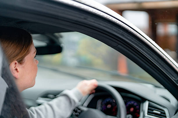 istock Driving at a cafe drive-thru on a rainy day with a focused driver 2239805584
