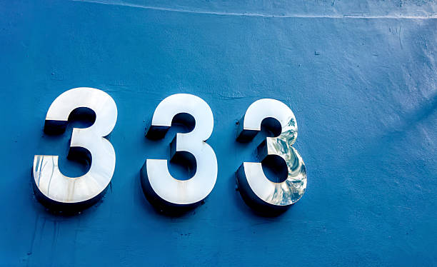istock Shiny chrome building number 333 attached on concrete wall 2239808013