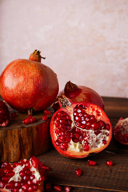 istock Fresh pomegranate on the wooden table vertical photo 2239810649