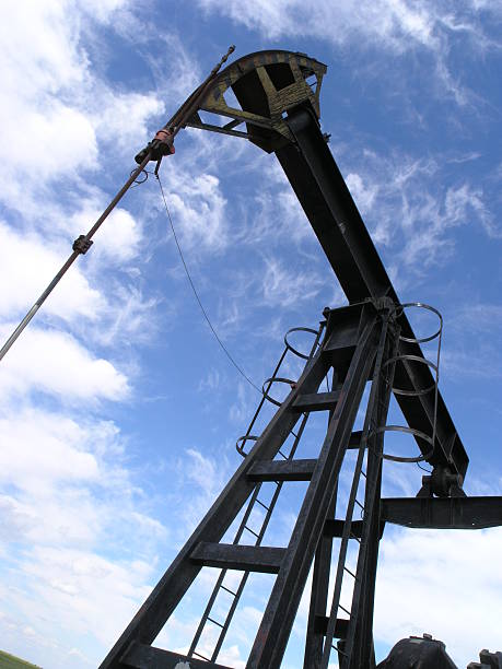 A cloudy sky with a few oil rigs in the background. The sky is a mix of blue and purple