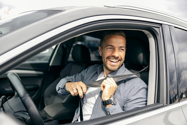 istock Man fastening seat belt, smiling inside car 2239811598