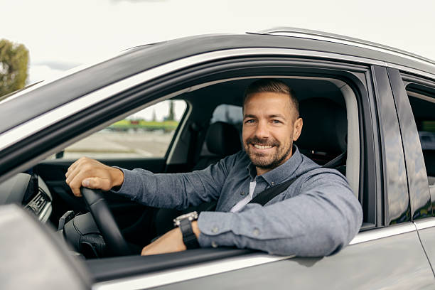 istock Happy man driving car looking at camera 2239811666