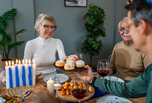 istock Family celebrating Hanukkah around traditional dinner table 2239811690