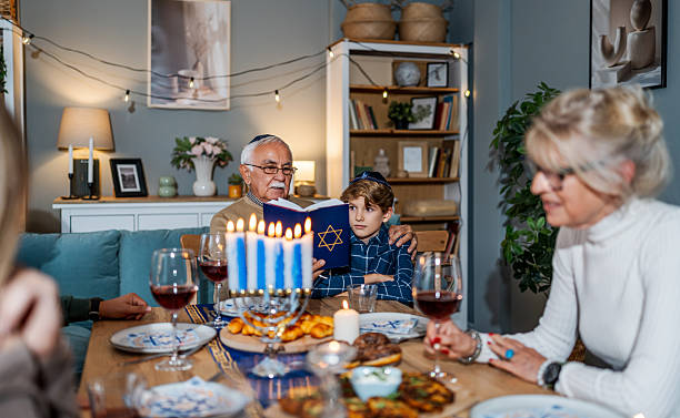 istock Family celebrating Hanukkah reading from the torah at dinner table 2239811955