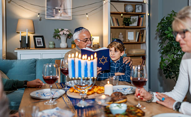 istock Grandfather and boy celebrating Hanukkah reading torah book 2239812827
