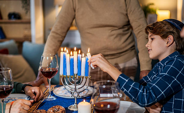istock Jewish boy lighting candles on menorah during Hanukkah celebration 2239812979