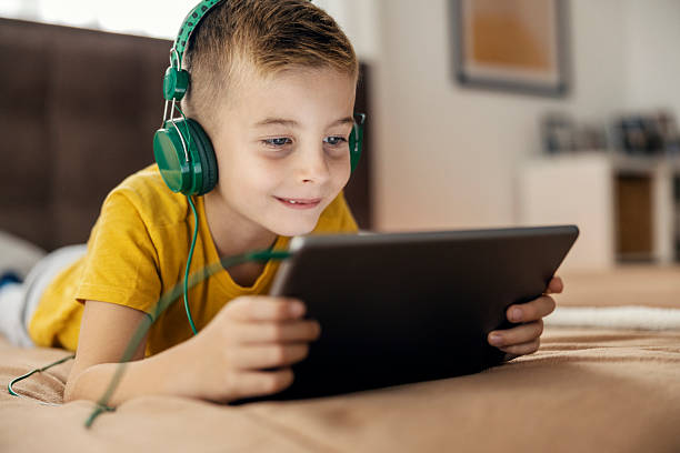 istock Boy using digital tablet with headphones for entertainment 2239814580