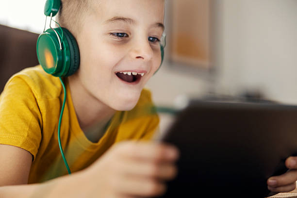 istock Boy enjoying digital entertainment with headphones and tablet 2239814582