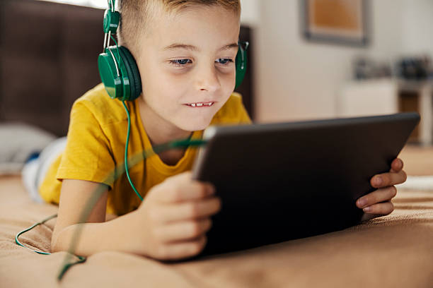 istock Boy with headphones using tablet for entertainment 2239814586