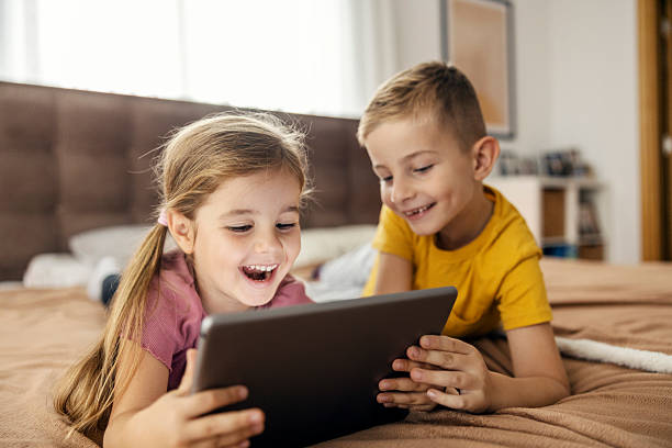 istock Children sharing digital tablet on bed, watching video 2239814641