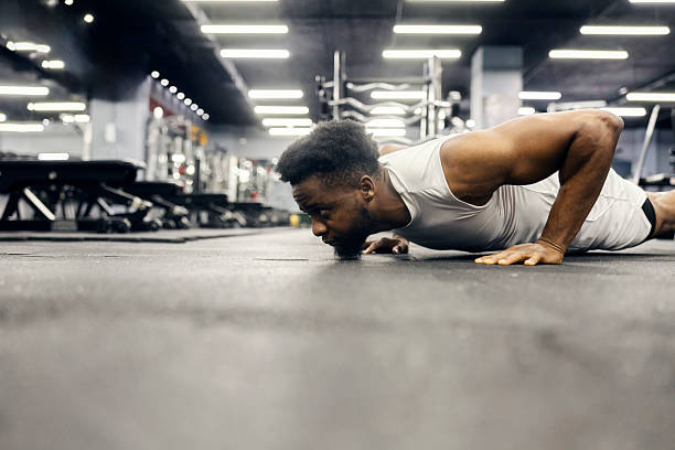istock Black man doing push-ups during intense workout in gym 2239818005