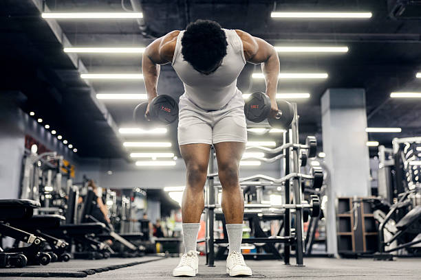 istock Man performing bent-over dumbbell row in gym 2239818036