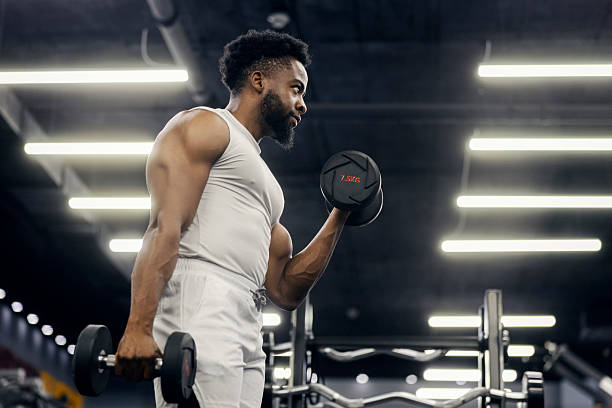 istock Black man lifting dumbbells doing bicep curl in gym 2239818040