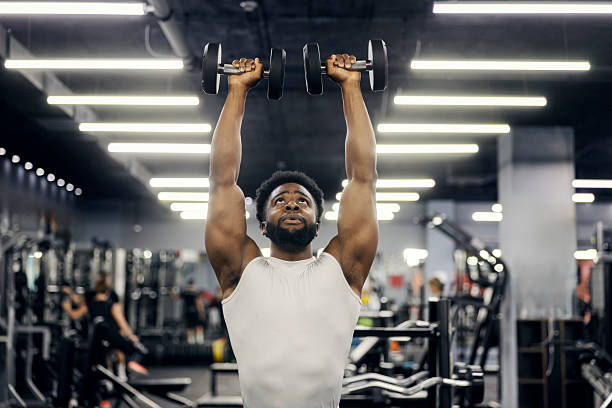 istock Man training with dumbbells in modern gym 2239818043