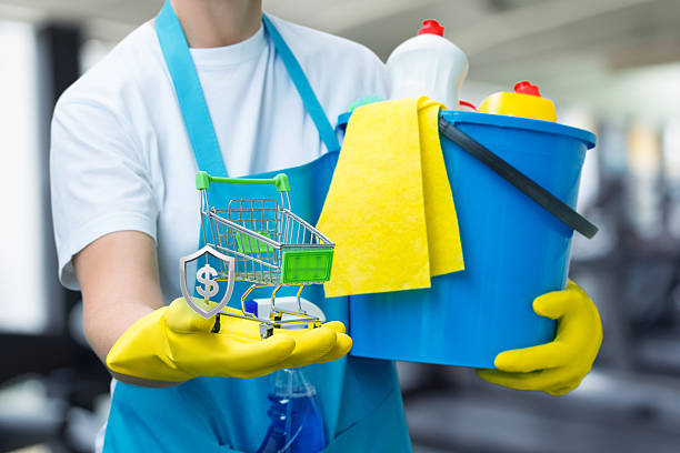 Wearing gloves and smiling while cleaning a gym area. A person in gloves holds a cleaning bucket and a tiny shopping cart ready to tidy up a fitness space.