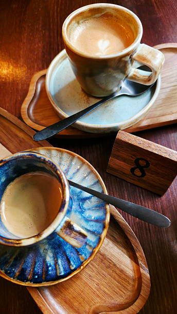 istock Two cups of coffee in a cafe on table number eight 2239821718