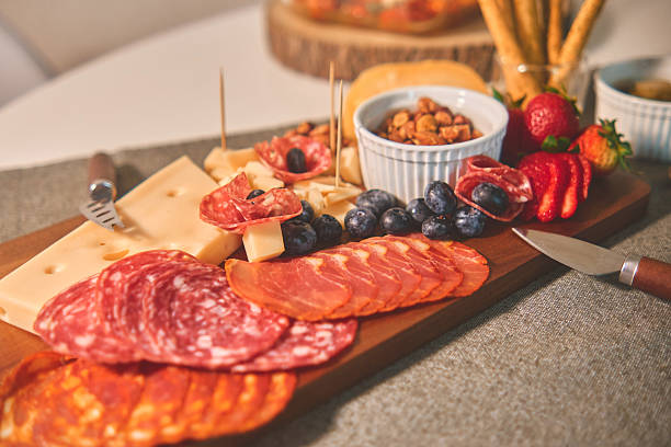 istock Charcuterie board served on a gray placemat, featuring various appetizers for a snack party 2239823517