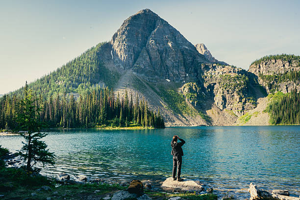 Scenic mountain lake vista: serene waters reflecting majestic peak and forest.