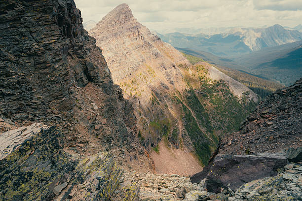 Mountain peak view from a rocky overlook, layers of mountains in the distance.