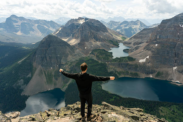 Mountain peak triumph: hiker celebrates scenic vista with arms outstretched.