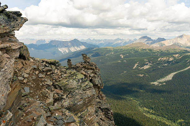 Mountain Vista: Rocky Outcrop Overlooking Forest Valley and Distant Peaks