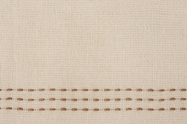 istock Beige fabric texture with brown stitched line macro photo as background. 2239828755