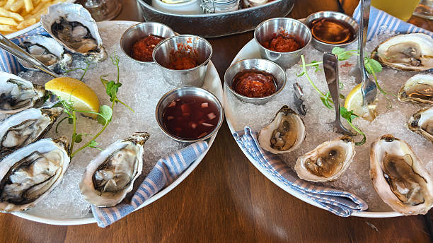 istock Fresh oysters on ice with sauces and lemon wedges 2239828778