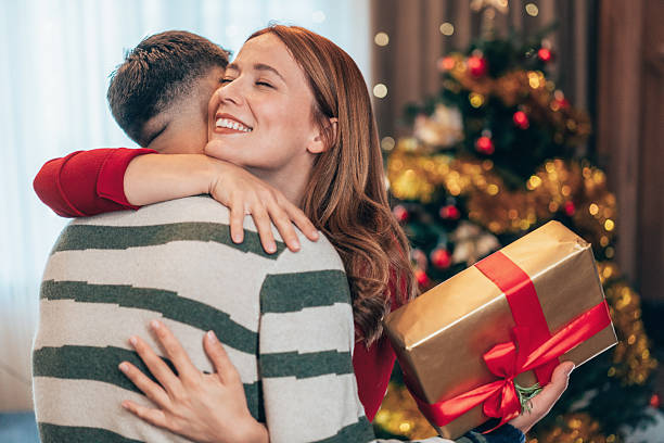 istock Cheerful couple exchanging Christmas presents 2239830437