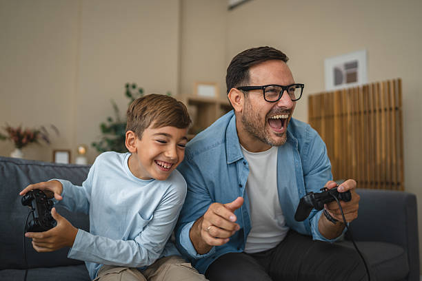 istock Excited dad and son enjoy while play video games at home 2239830523