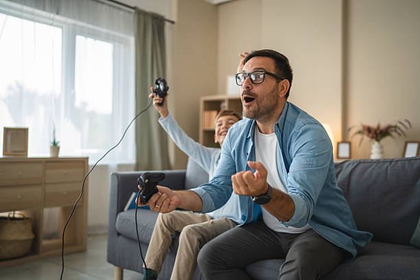 istock Excited dad and son enjoy while play video games at home 2239830539