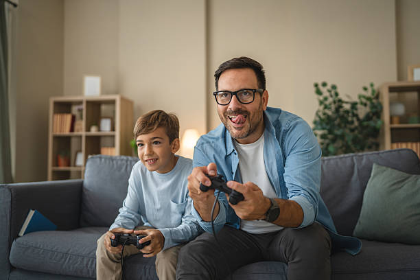 istock Excited dad and son enjoy while play video games at home 2239830585