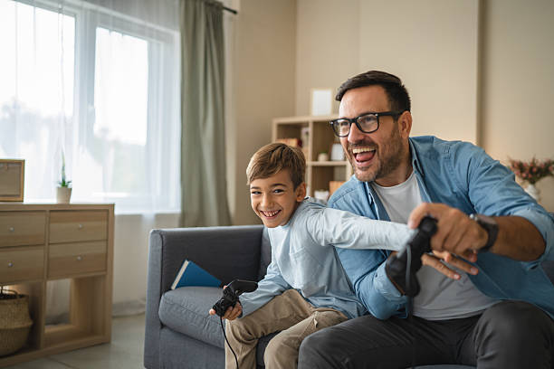 istock Excited dad and son enjoy while play video games at home 2239830588