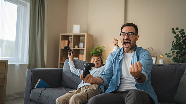 istock Excited dad and son enjoy while play video games at home 2239830867