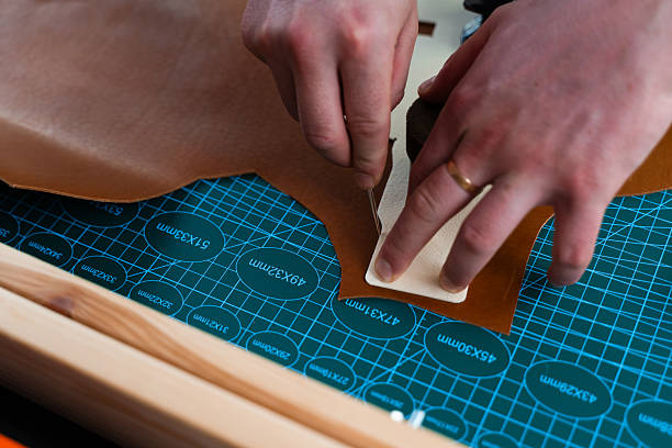 istock Leather crafting process showing precise cutting. Skilled artisan cuts leather with accuracy. Leather Cutting with Pattern. Leather artisan uses templates to cut hides accurately. 2239830906