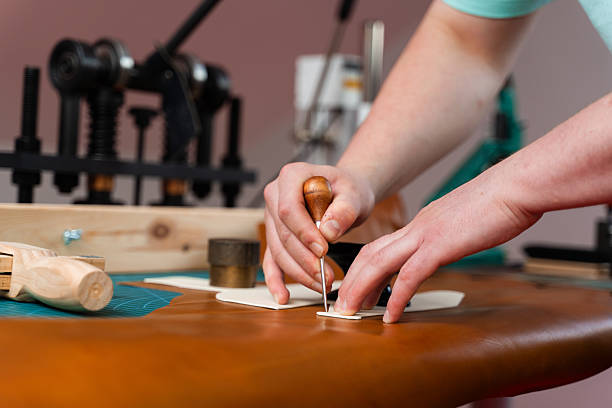 istock Leather crafting process showing precise cutting. Skilled artisan cuts leather with accuracy. Leather Cutting with Pattern. Leather artisan uses templates to cut hides accurately. 2239830951
