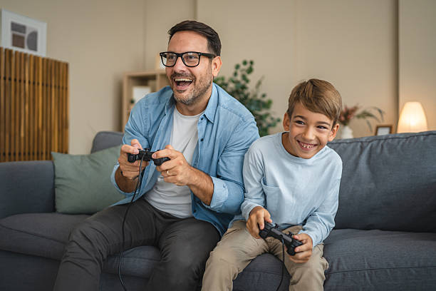 istock Excited dad and son enjoy while play video games at home 2239831006