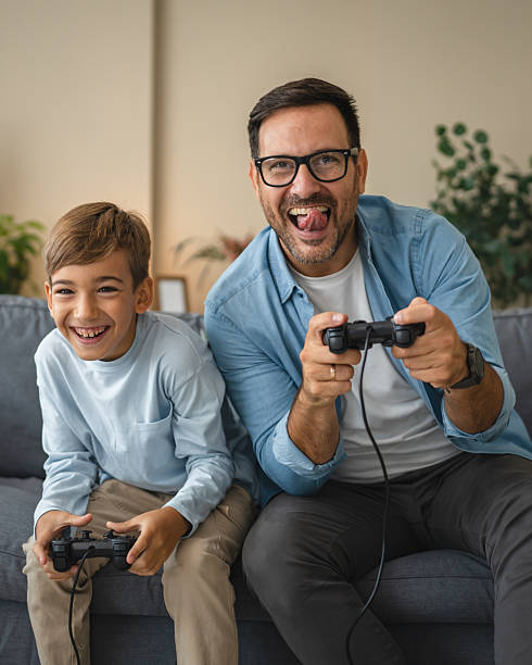 istock Excited dad and son enjoy while play video games at home 2239831053