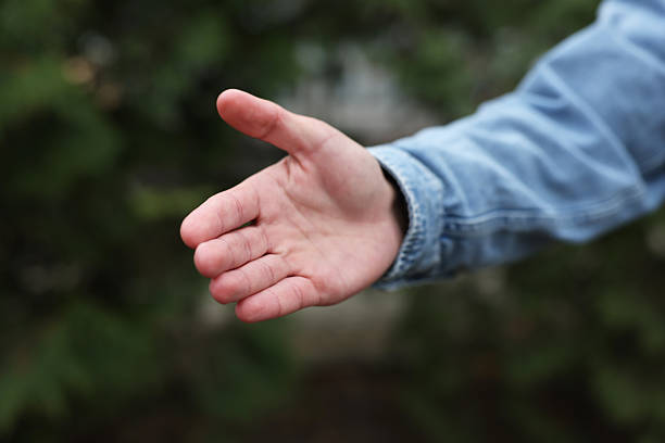 istock Offering help. Man reaching his hand outdoors, closeup 2239831927