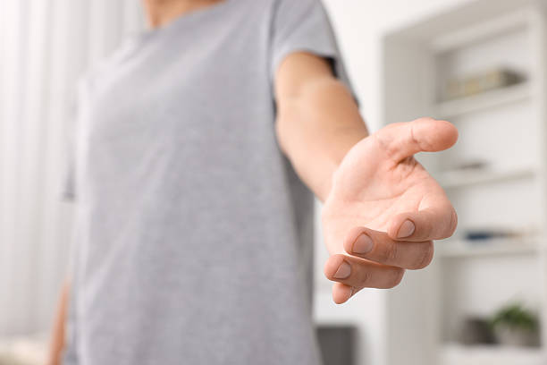 istock Offering help. Man reaching his hand indoors, closeup 2239831945