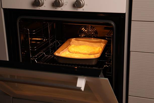 istock Baking dish with uncooked calzone pizza in oven 2239833420