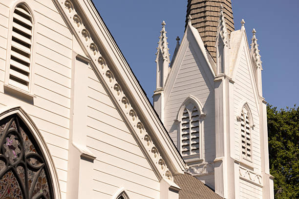 Daylight shines on lush foliage and historic church in the town of Atherton, California, USA.