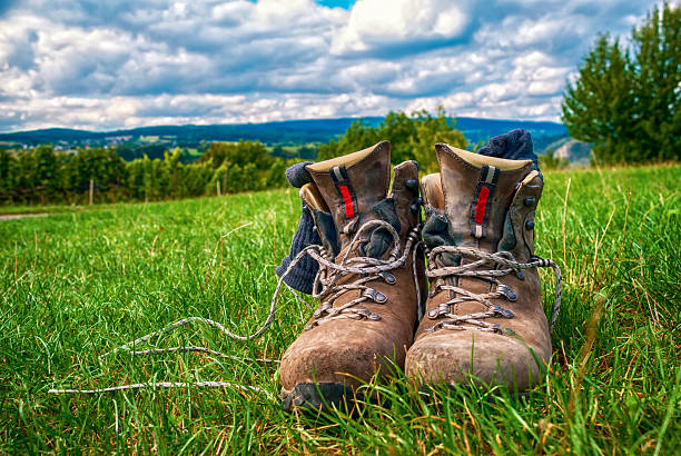 Heavily used and worn hiking boots in green grass