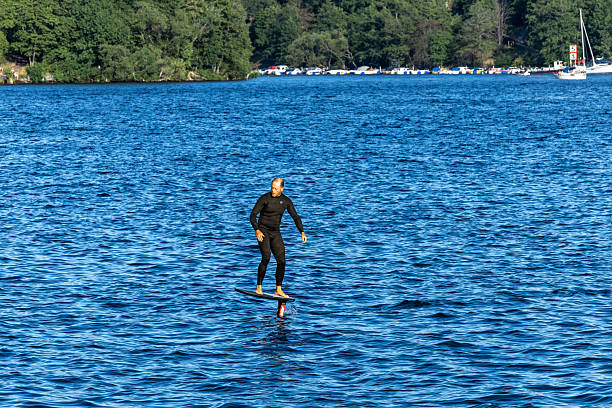 Stockholm, Sweden, July 27, 2025 A man rides an electric foil surfing board  in the downtown
