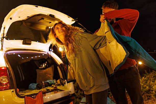 istock Autumn camping adventure at night with friends preparing for warmth under string lights in a cozy outdoor setting 2239843657